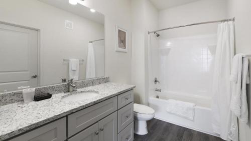 a white bathroom with a sink and a toilet at Landing - Modern Apartment with Amazing Amenities (ID1401X786) in Fort Worth