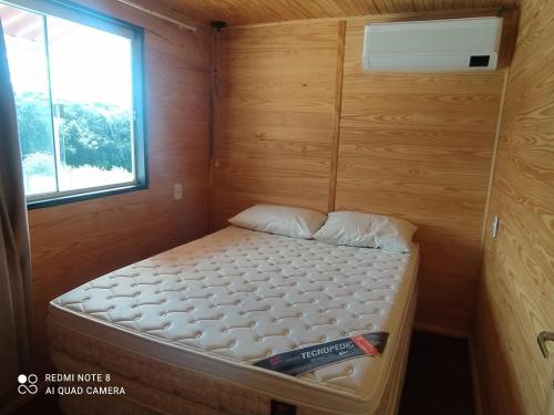 ein kleines Bett in einem kleinen Zimmer mit Fenster in der Unterkunft Casa Container Amarela in Bagé