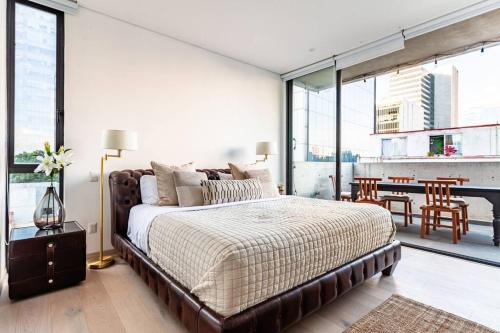 a bedroom with a large bed and a dining room at Penthouse, terraza privada y estacionamiento in Mexico City