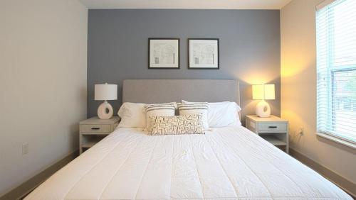 1 dormitorio con 1 cama blanca grande y 2 mesitas de noche en Landing Modern Apartment with Amazing Amenities (ID2613X64) en Detroit