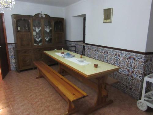 una mesa de madera y un banco en una habitación en One bedroom house with terrace and wifi at Miranda do Corvo, en Vale de Colmeias