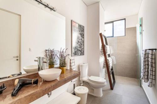 a bathroom with a sink and a toilet and a shower at Penthouse, terraza privada y estacionamiento in Mexico City