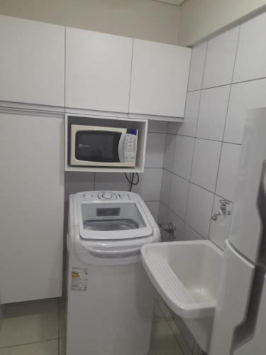 un piccolo bagno con forno a microonde sopra un lavandino di Villa damasco a Fortaleza