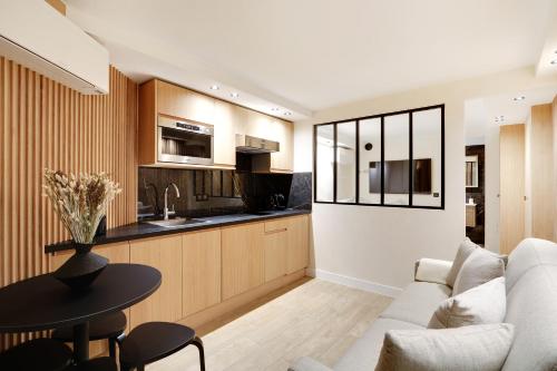 un salon avec un canapé blanc et une table dans l'établissement Pick A Flat's Apartment in Odeon - Rue Saint André des Arts, à Paris