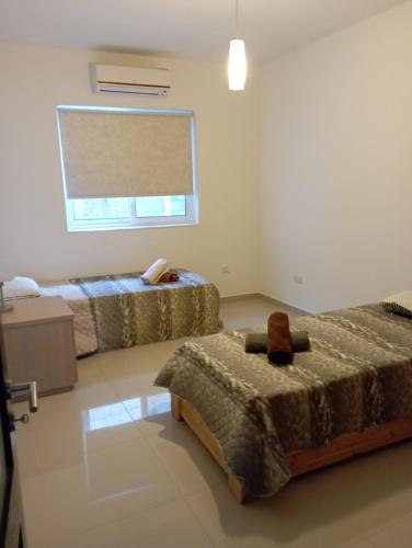 a bedroom with two beds and a window at Apartment in San Julijans in St Julian's