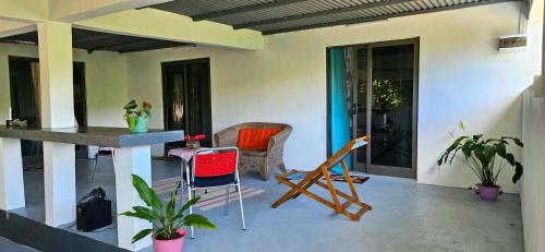 a patio with chairs and a table on a house at Le lataniers in Rodrigues Island