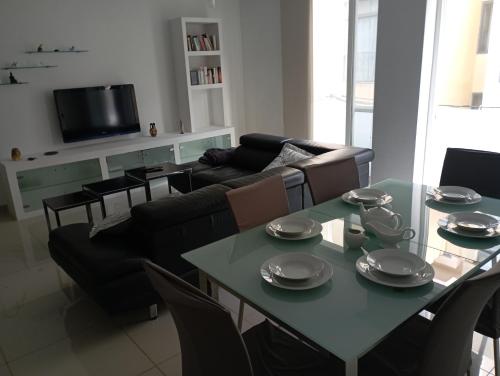 un soggiorno con tavolo e divano di Apartment in San Julijans a San Giuliano