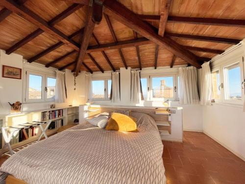 a bedroom with a bed in a room with windows at Casa della Chiocciola: In Centro in Siena