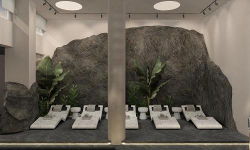 Paros Agnanti Resort & Spa في باريكيا: غرفة بها مجموعة من الكراسي أمام صخرة