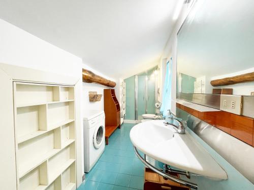 a bathroom with a sink and a washing machine at Casa della Chiocciola: In Centro in Siena