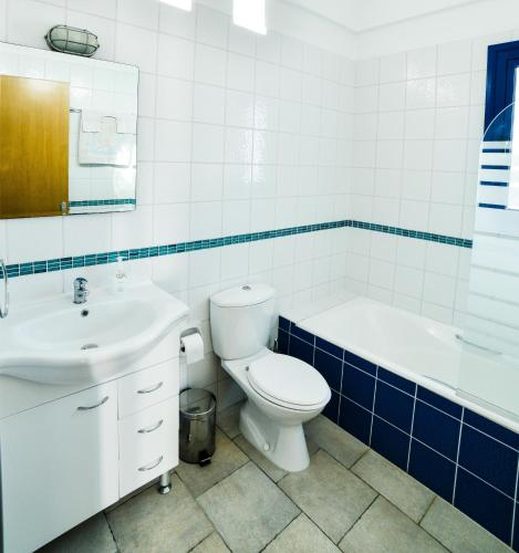 a bathroom with a toilet and a tub and a sink at Azzurro Holiday Villas in Peyia