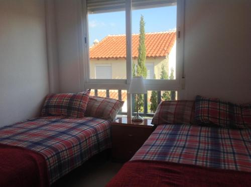 2 camas en una habitación con ventana en Casa Cortijo de Calahonda, en La Cala de Mijas