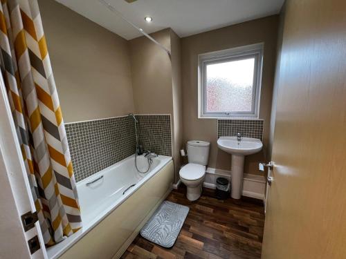 a bathroom with a tub and a toilet and a sink at Crownford Guesthouse - Close to Hanley centre and University in Stoke on Trent