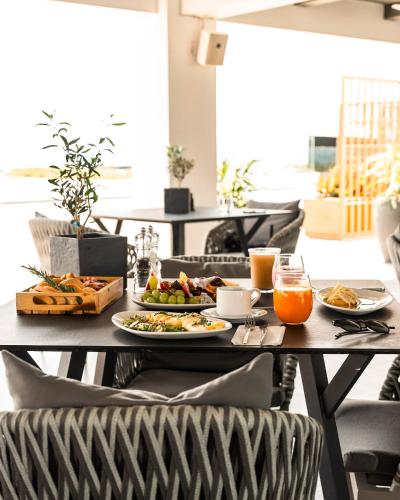 a table with plates of food and orange juice at Gennadi Grand Resort in Gennadi