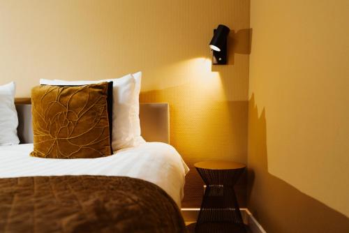 a bedroom with a bed with a pillow and a lamp at Hotel Janssen in Valkenburg