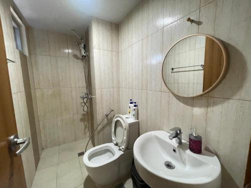 a bathroom with a sink and a toilet and a mirror at One-bedroom Condo with Balcony in Manila near US Embassy in Manila