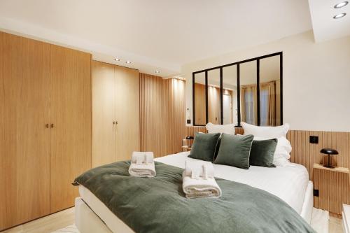 une chambre avec un grand lit avec des serviettes dessus dans l'établissement Pick A Flat's Apartment in Odeon - Rue Saint André des Arts, à Paris