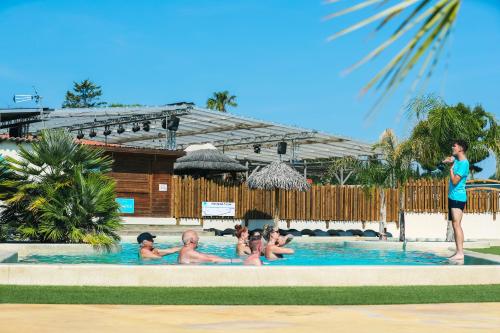 un grupo de personas sentadas en una piscina en Camping Paradis Le Pearl, en Argelès-sur-Mer