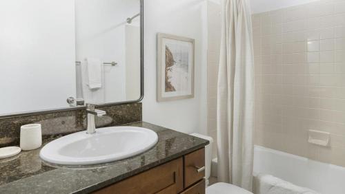 La salle de bains blanche est pourvue d'un lavabo et d'une baignoire. dans l'établissement Landing Modern Apartment with Amazing Amenities (ID1248X586), à Boulder