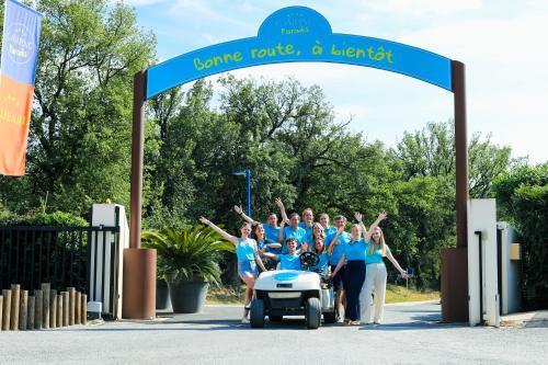 a group of people standing under a welcome sign at Camping Paradis Le Pearl in Argelès-sur-Mer