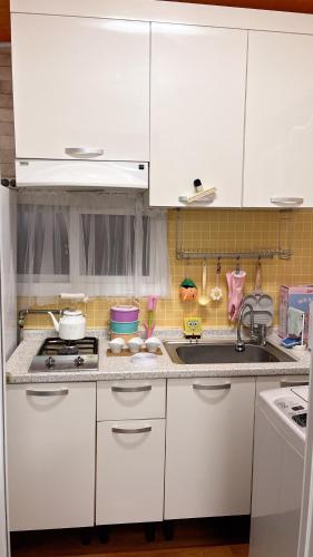 a kitchen with white cabinets and a sink at Tiny house in Ulsan