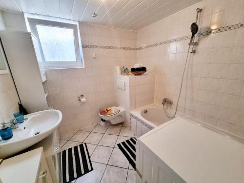 a bathroom with a tub and a toilet and a sink at Cosy Apartment in Groß-Rohrheim – 87 m² – Sunny Terrace in Groß-Rohrheim