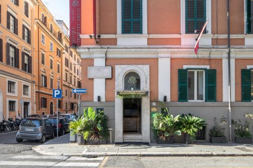 羅馬的住宿－蒙特卡洛酒店，城市街道上的一座建筑物,有车辆停放