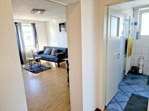 korytarzem prowadzącym do salonu z kanapą w obiekcie 2 bedrooms appartement with balcony and wifi at Neckarau Mannheim w mieście Neckarau