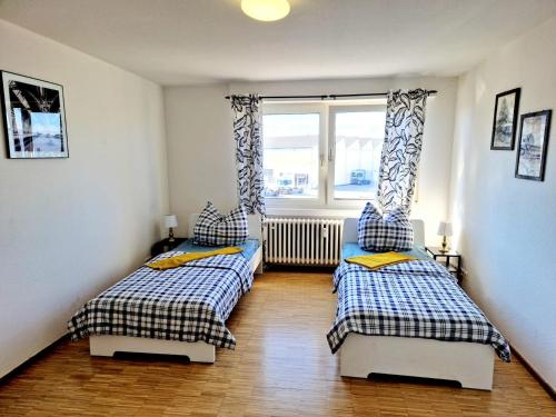 two twin beds in a room with a window at 2 bedrooms appartement with balcony and wifi at Neckarau Mannheim in Neckarau