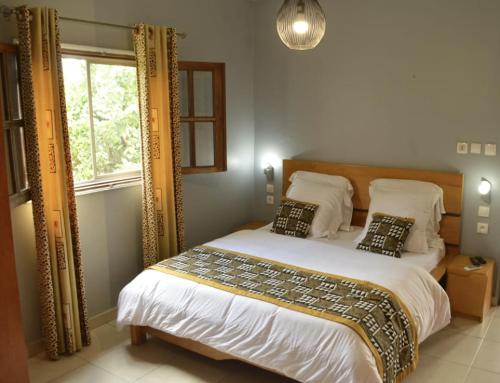 sypialnia z łóżkiem i dużym lustrem w obiekcie BUNGALOW'S PLAZA KRIBI w mieście Kribi