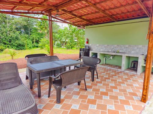 a patio with a table and chairs and a fireplace at Confort Arenal in Fortuna