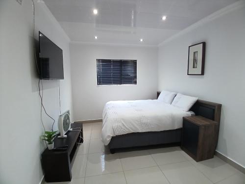 a bedroom with a bed and a flat screen tv at One bedroom apartment. in Cape Town