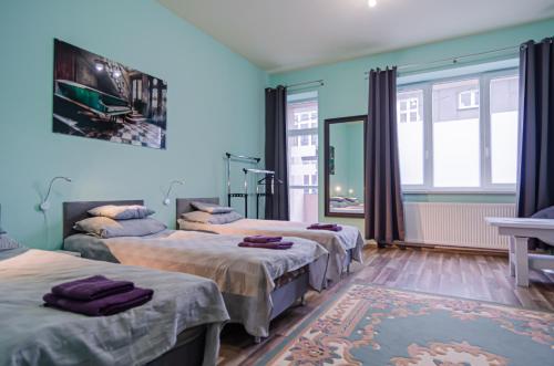 2 camas en una habitación con paredes y ventanas azules en OMMP CENTRUM, en Częstochowa