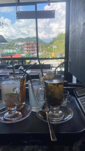 three cups of coffee on a table with a view at Aati cafe in Pokhara