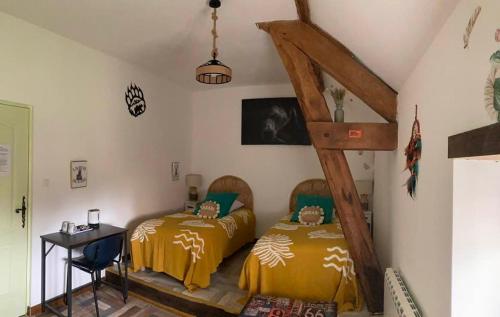 a bedroom with two beds and a table and a desk at Morvan Séjours in Antully