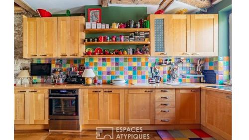 une cuisine avec des placards en bois et du carrelage sur le mur. dans l'établissement Paris Best view w/Rooftop!, à Paris