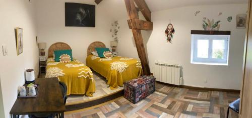 a bedroom with two beds with yellow sheets and a window at Morvan Séjours in Antully