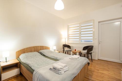a bedroom with a bed with towels on it at V & V Studio Apartments 2 in Niš
