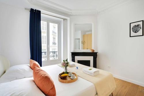 Cette chambre blanche dispose d'un lit et d'une cheminée. dans l'établissement Renovated and modern 4BD for 12 guests, à Paris