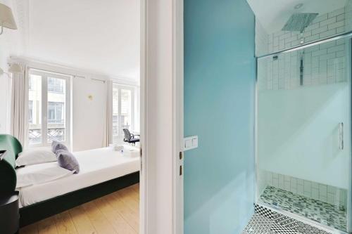 La salle de bains est pourvue d'un lit, d'un lavabo et d'une douche. dans l'établissement Renovated and modern 4BD for 12 guests, à Paris