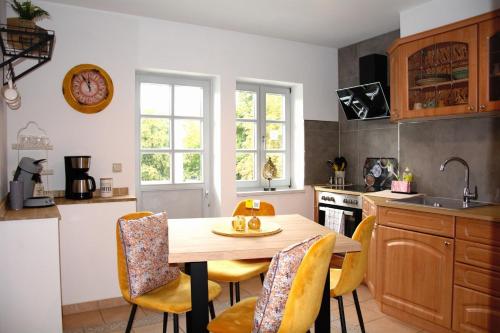 uma cozinha com uma mesa e cadeiras numa cozinha em Rosenwinkel Maisonettewohnung DG em Halberstadt