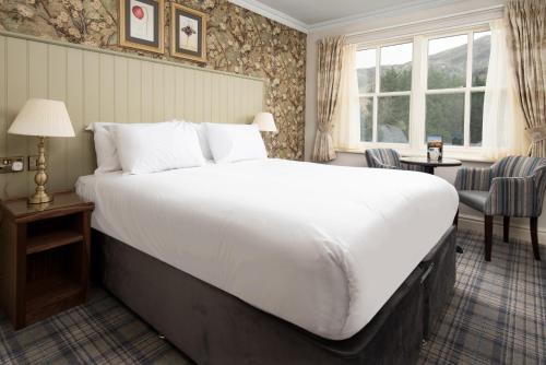 - un grand lit blanc dans une chambre d'hôtel dans l'établissement The Ullswater Inn- The Inn Collection Group, à Glenridding