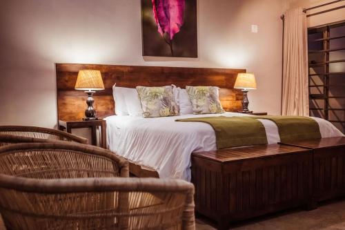 a bedroom with a large bed and two chairs at Bushveld Terrace Safari Hotel, Lodge & Spa in Phalaborwa