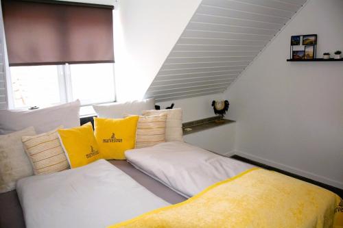 uma cama com almofadas amarelas e brancas num quarto em Rosenwinkel Maisonettewohnung DG em Halberstadt