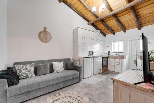 a living room with a couch and a kitchen at Casa da Travessa - Lago do Alqueva in São Marcos do Campo