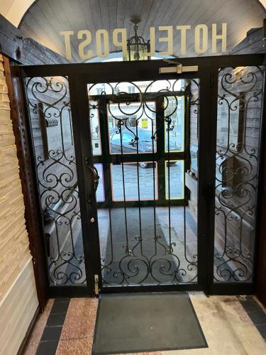 an entrance door to a building with a wrought iron gate at City Hotel Post 12 in Braunau am Inn