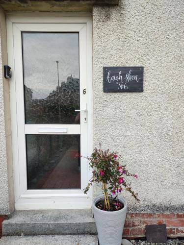 a door to a house with a potted plant in front at Taigh Shen in Stornoway