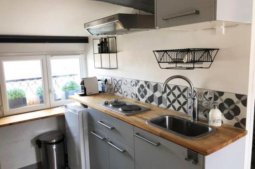a kitchen with a sink and a counter top at Suites Rive Gauche - FONTAINEBLEAU - Chez Andrea in Fontainebleau