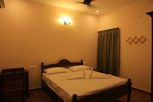 a bedroom with a bed and a ceiling fan at Ponni Homestay Kumbakonam in Kumbakonam