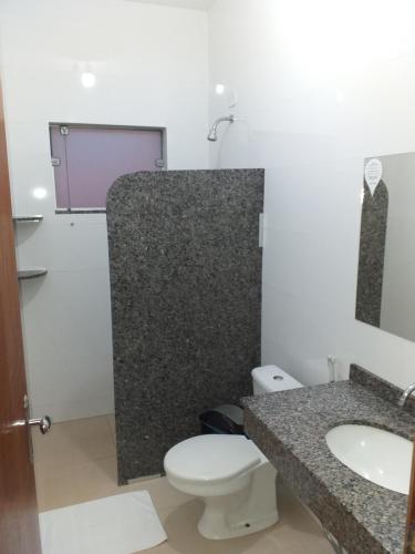 a bathroom with a toilet and a sink at Lisboa Palace Hotel in Alta Floresta